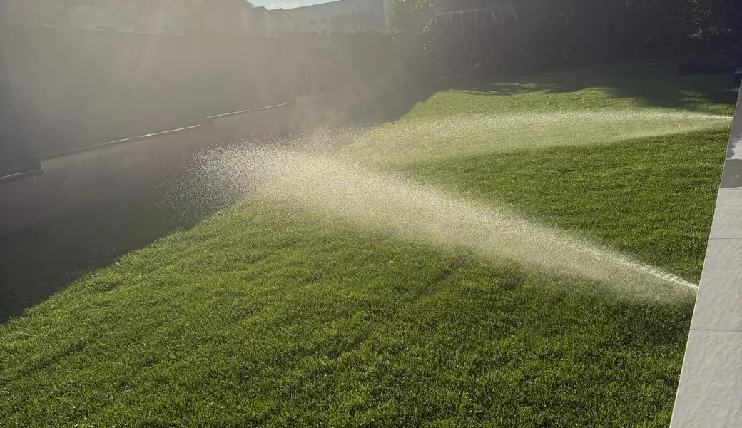 Arrosage automatique en action sur une pelouse dense entretenue par Les Jardins d'Erwan, paysagiste à Amnéville