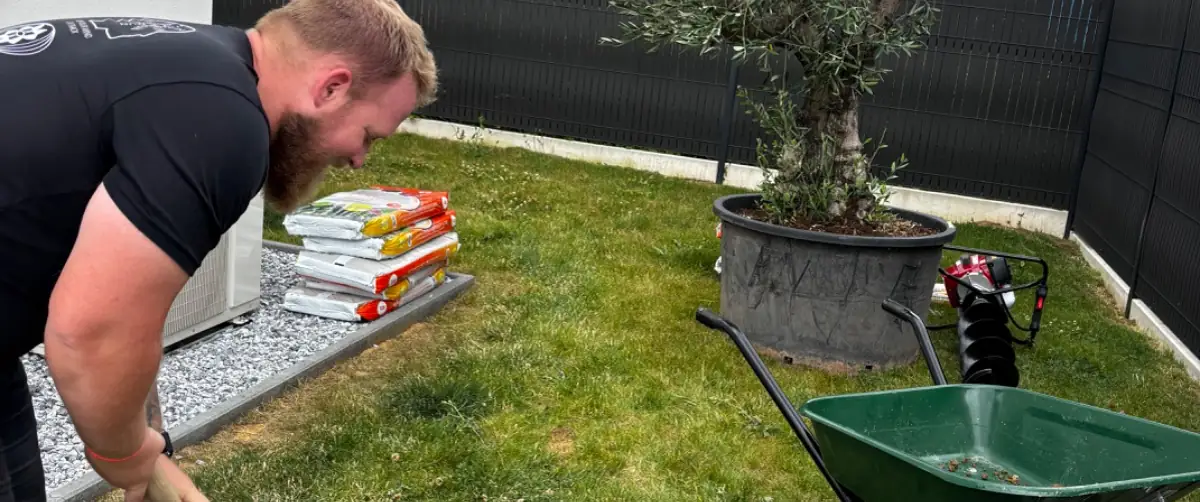 Paysagiste des Jardins d'Erwan plantant un olivier chez un client en Moselle