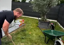 Paysagiste des Jardins d'Erwan plantant un olivier chez un client en Moselle