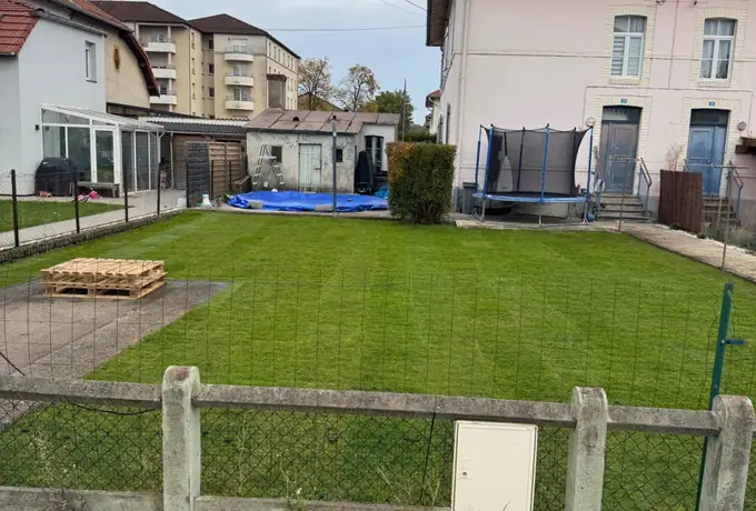 Pelouse tondue et terrain nettoyé devant une maison, entretien réalisé par Les Jardins d'Erwan à Amnéville