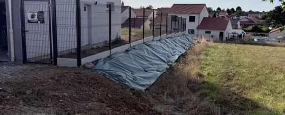 Clôture rigide et portillon posés le long d'une maison, chantier de paysagement