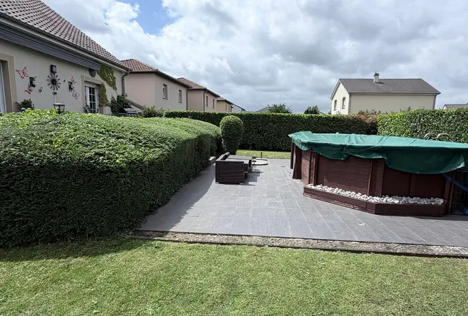 Haie taillée au cordeau et if taillé en boule le long d'une terrasse de jardin